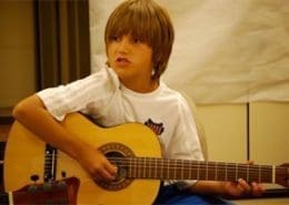 Child playing guitar and singing.
