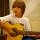 Child playing guitar and singing.