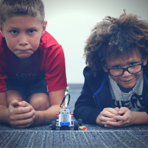 Two friends prepare to race their LEGO bricks race car.