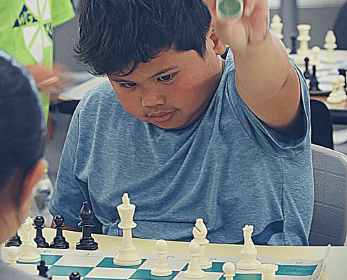 YEL chess student prepares to capture the piece from his opponent.