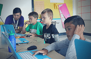 A YEL Coding instructor helps his students.