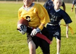 A young flag football player goes for the touchdown.