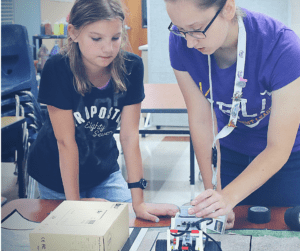 YEL Robotics teacher helps student with a challenge.