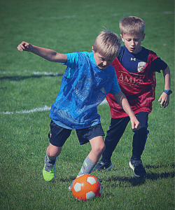 YEL soccer classes for kids. Two kiddos battling for the ball.