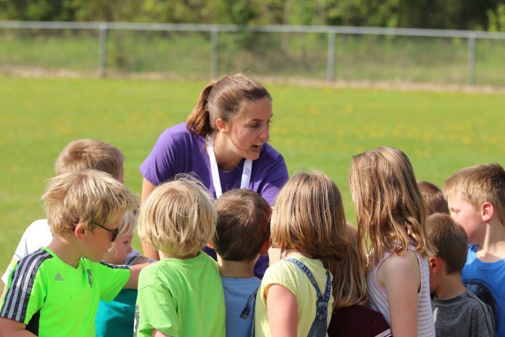 Coach giving pep talk to soccer team.Adult supervision minimizes risky behavior.