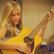 Girl smiling while playing guitar