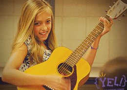 Girl smiling while playing guitar