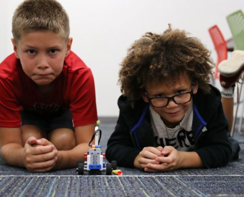 Two Brick Builder students prepare to race their car made out of LEGO Bricks.