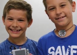 Two boys display their Brick Builders project.