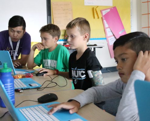 YEL Coding teacher instructs students on video game creation.