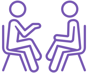 Two people sitting on chairs chatting.