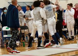 2023 Team State Champions, {YEL!} SE MN Fencing Team. All the teammates are huddled and cheering.