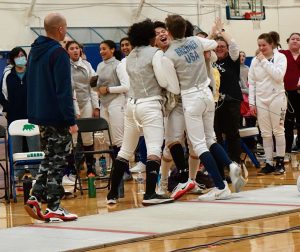 2023 Team State Champions, {YEL!} SE MN Fencing Team. All the teammates are huddled and cheering.