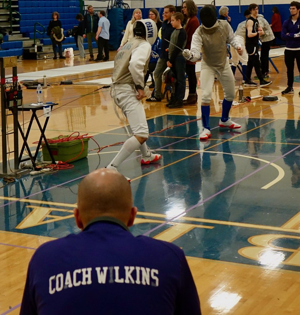 Coach Kamau Wilkins as his son, Mateo, fences in the 2023 State Tournament.