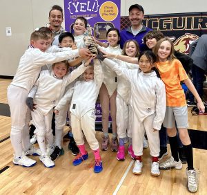 Rochester, MN Fencing Club holds up their first place trophy at the May 2024 fencing tournament.