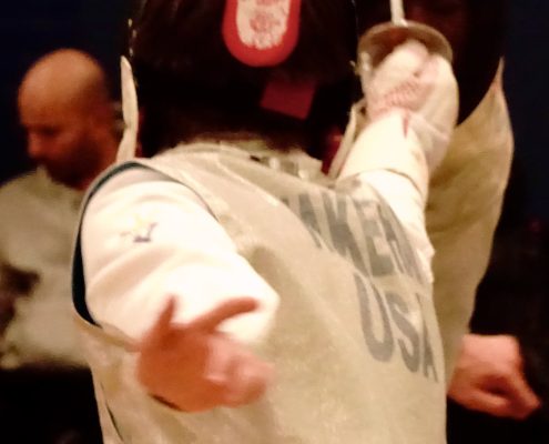 Closeup of a fencer's back delivering an excellent touch against an opponent.