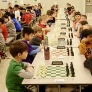 Chess players lined up in long rows of chess boards as they prepare to start their tournament chess games. Chess Club.